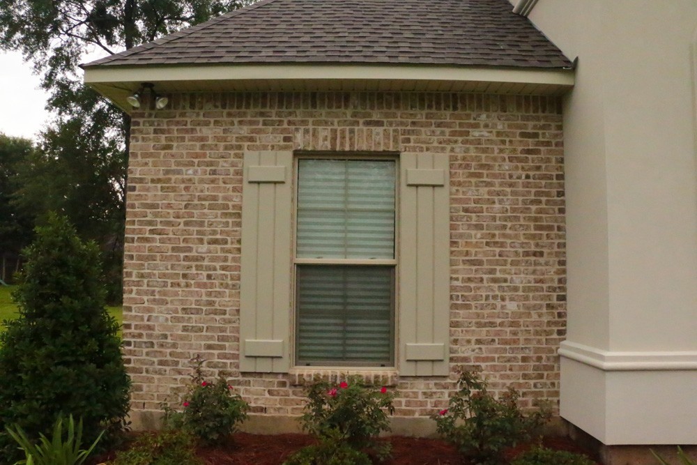 Tan board and batten shutters on Metairie home - Strong Shield